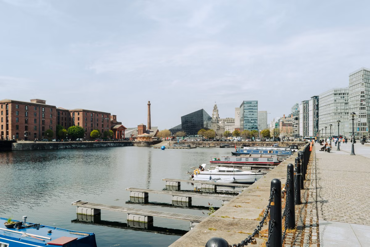 Liverpool waterfront with moored boats and the Royal Liver Building in the distance