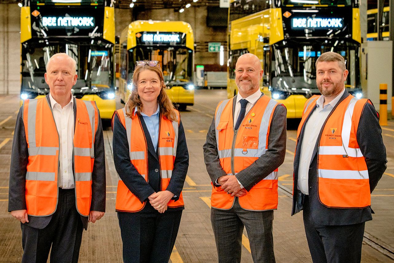 Electric buses parked at charging points in a bus depot